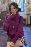 Woman wearing a purple sweater in an indoor setting