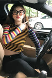 Person wearing a colorful striped shirt sitting inside a car.