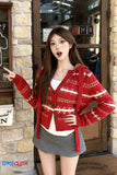 Woman wearing a red patterned cardigan pointing at a door with 'OPEN' sign.