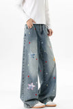 Denim pants with star patches worn by a person on a white background