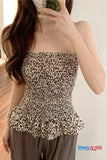 Person wearing a leopard print strapless top with ruffled details, holding a phone.