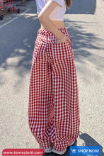 Person wearing red and white checkered pants on a street.