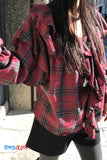 Person wearing a red and black plaid shirt with 'TomsCloth' branding.