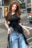 Woman in black top and blue jeans standing on a city street.