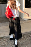 Person wearing a white t-shirt, black polka dot pants, and a red backpack outdoors.