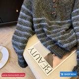 Person wearing a gray and blue striped sweater with a 'BEAUTY' sign in the foreground.