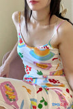 Person wearing a colorful dress with abstract patterns and 'TOMS CLOTH' branding.