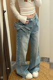 Person wearing light blue jeans with a bow detail, standing on a wooden floor.