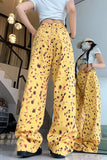 Person wearing yellow patterned pants and a white crop top in an indoor setting.