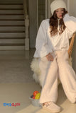 Person wearing a white outfit with fluffy texture sitting on a chair with a basket of fruits.