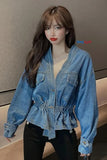 Person wearing a blue denim jacket against a neutral background