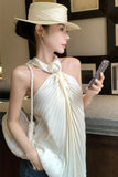 Woman wearing a white hat and holding a phone, with a plain background