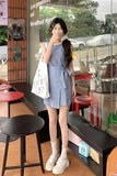 Woman in a checkered dress taking a selfie in a cafe.