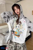 Person wearing a gray hoodie with cartoon designs in a room.