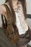 Person wearing a white lace top and brown leather outfit with a matching bag.