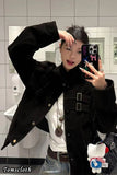 Person taking a mirror selfie wearing a black coat in a bathroom.