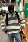 Person wearing a striped sweater in an indoor setting, possibly a store.