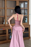 Woman wearing a pink dress with a wooden cabinet in the background