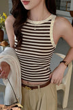 Woman wearing a striped tank top and beige pants in an indoor setting