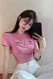 Person wearing a pink top with cut-out design, taking a mirror selfie.