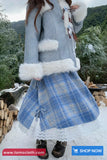 Person wearing a blue plaid coat with white fur trim in a snowy outdoor setting.