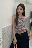 Woman wearing a plaid top and dark jeans in a tiled room.