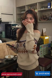 Woman in a patterned sweater using a smartphone in a kitchen setting with a 'Toms Cloth' advertisement.