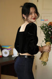 Woman holding flowers indoors with a blurred background