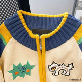 Colorful sweater with embroidered designs on a neutral background