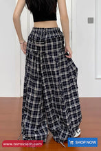 Person wearing black and white checkered pants with a plain background