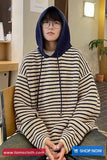Person wearing a striped hoodie sitting indoors with a promotional banner at the bottom.