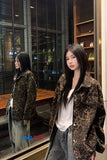 Woman wearing a leopard print jacket in a reflective indoor setting