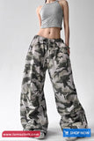 Person wearing camouflage pants and a gray crop top on a white background with 'tomscloth.com' branding.