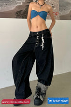 Person wearing a blue strapless top and black wide-leg pants with fur-trimmed shoes, standing against a plain background.