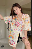 Woman wearing a colorful patterned shirt in a room.