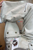 Beige pants with a visible brand tag on a wooden floor.
