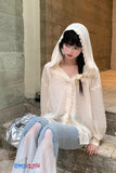 Person wearing a white hooded outfit sitting on a stone bench.
