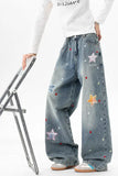 Person wearing blue jeans with star patches on a white background