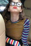 Person wearing a colorful striped shirt sitting in a car.