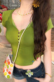 Woman wearing a green top with a pearl necklace and colorful handbag.