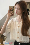 Woman taking a mirror selfie wearing a white lace top with buttons, holding a phone with a colorful case.