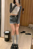 Person taking a mirror selfie wearing a crop top, denim skirt, and knee-high socks.