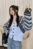 Woman wearing a striped cardigan and blue shirt, sitting on a couch.