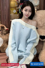 Woman wrapped in a light blue blanket with decorative items in the background