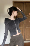 Person wearing a dark gray ribbed sweater with a zipper in a room with wooden doors.