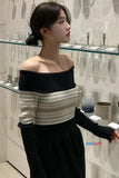 Woman wearing a black and white off-shoulder top in an indoor setting