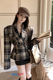 Woman in plaid blazer and cap holding a book, with 'Toms Cloth' branding.