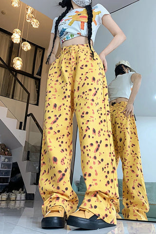 Person wearing a colorful top and yellow patterned pants in an indoor setting.