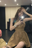 Woman taking a mirror selfie wearing a brown dress in an indoor setting.