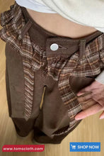 Brown plaid shirt with ruffled details on a wooden surface, featuring a 'Shop Now' button at the bottom.